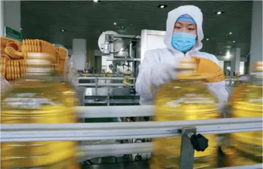  ??  ?? A worker is busy on the production line of corn oil at Sanxing Group Co. Ltd. in Zouping, Shandong Province in east China, on March 14