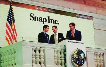  ?? Reuters ?? Snap cofounders Evan Spiegel (centre) and Bobby Murphy ring the opening bell of the New York Stock Exchange with NYSE Group President Thomas Farley shortly before the company’s IPO yesterday.