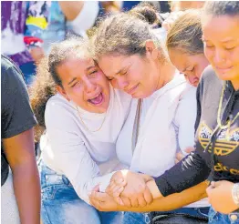  ?? AP ARIANA CUBILLOS ?? A sister of miner Santiago Mora, left, cries with other relatives as he is buried at the cemetery in La Paragua, Bolivar state, Venezuela, yesterday.