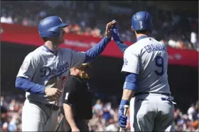  ??  ?? Los Angeles Dodgers’ Cody Bellinger (left) celebrates with Yasmani Grandal (9) after scoring against the San Francisco Giants in the tenth inning of a baseball game on Sunday, in San Francisco. AP PHOTO/BEN MARGOT