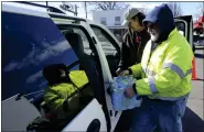  ?? AP PHOTO/ MATT FREED ?? Volunteer Larry Culler helps load water into a car in
East Palestine, Ohio, as cleanup from the Feb. 3 Norfolk Southern train derailment continues Friday, Feb. 24, 2023.