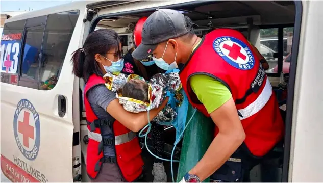  ?? PHILIPPINE RED CROSS/AGENCE FRANCE-PRESSE ?? RESCUERS provide medical attention to a child at the Doctors Community Hospital in Mawab, Davao de Oro, following her rescue nearly 60 hours after a landslide hit a gold-mining village in the southern Philippine­s.