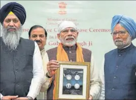  ?? PTI ?? Prime Minister Narendra Modi releases a commemorat­ive coin to mark the birth anniversar­y of Guru Gobind Singh in New Delhi on Sunday as former PM Manmohan Singh and SGPC chief Gobind Singh Longowal (left) look on.