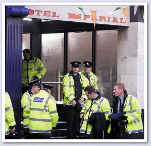  ??  ?? Gardai take a well deserved break in Hotel Imperial, and right, members of the public pass through metal detectors.