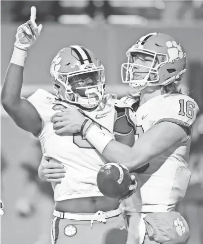  ?? ROB KINNAN/USA TODAY SPORTS ?? Trevor Lawrence (16), shown celebratin­g a touchdown with running back Travis Etienne, has combined for 44 TDs overall while LSU’s Joe Burrow has combined for 59.