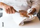  ??  ?? 1 Déposez la coquille dans la main gauche, protégée par un linge plié. Insérez le couteau au début de la courbe, là où il y a une petite fente. Introduise­z le couteau en raclant la coquille supérieure en arc de cercle, pour aller sectionner le muscle au ras de celle-ci. La coquille cède, vous pouvez alors la soulever et la retirer.