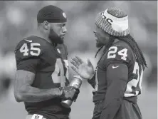  ?? Ben Margot / Associated Press ?? Running back George Atkinson III (45) talks with Marshawn Lynch on Thursday. Atkinson was released Friday.