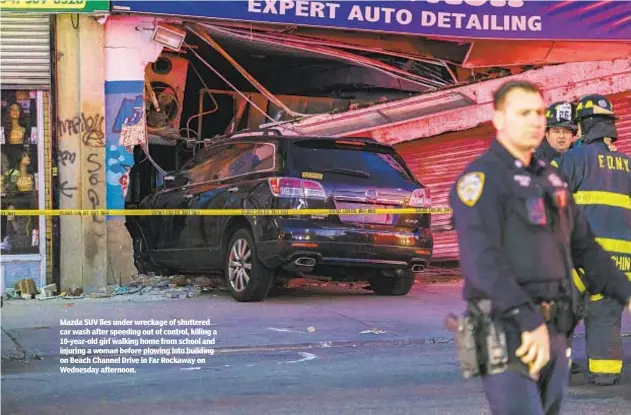  ?? ?? Mazda SUV lies under wreckage of shuttered car wash after speeding out of control, killing a 10-year-old girl walking home from school and injuring a woman before plowing into building on Beach Channel Drive in Far Rockaway on Wednesday afternoon.