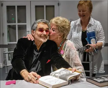  ?? DAMON HIGGINS / THE PALM BEACH POST 2016 ?? Legendary actor Burt Reynolds, who grew up in Palm Beach County, receives a smooch from his high school sweetheart, Ann (Lawlor) Scurry, at a book signing at the Palm Beach Book Festival on April 2, 2016.