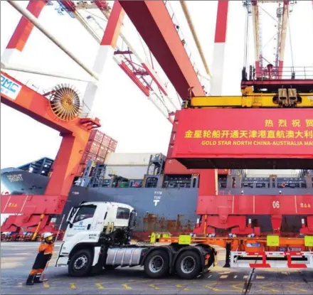  ?? TONG YU / CHINA NEWS SERVICE ?? A container is hoisted from a ship berthed at Tianjin Port Alliance Internatio­nal Container Terminal on Feb 28, w a port in the city since the RCEP took effect.