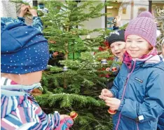  ?? Foto: Anja Fischer ?? Stolz hängen die Mädchen aus der Religionsg­ruppe der 2. Klassen der Laurentius schule ihre Glöckchen aus Teekapseln an den Baum.