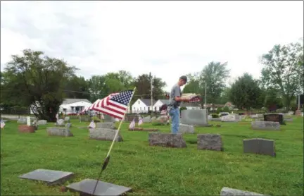  ?? TYLER RIGG — THE NEWS-HERALD ?? Members of American Legion Post 214 in Willoughby plant flags at the Sharpe Avenue Cemetery.