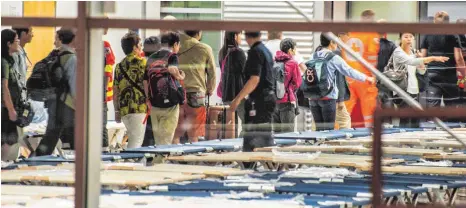  ?? FOTO: DPA ?? Die etwas andere Nacht: Passagiere der Korean-Air-Maschine werden im Flughafen Stuttgart zu vorbereite­ten Feldbetten geführt.