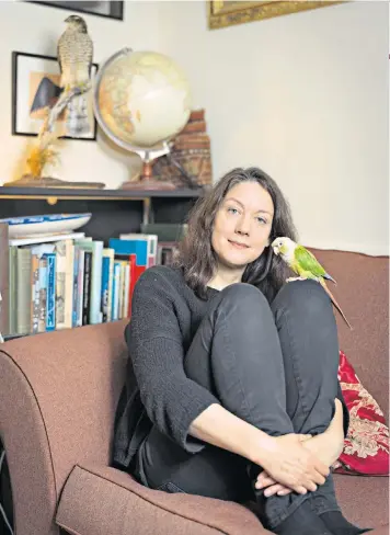  ??  ?? Home but not alone: Helen Macdonald in the Suffolk terrace she shares with Birdoole, her 14-year-old green-cheeked conure