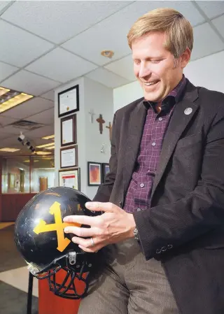  ?? JIM THOMPSON/JOURNAL ?? In his office, Albuquerqu­e Mayor Tim Keller proudly displays his black St. Pius High School helmet and points out some of the hits he took as a quarterbac­k for the school.