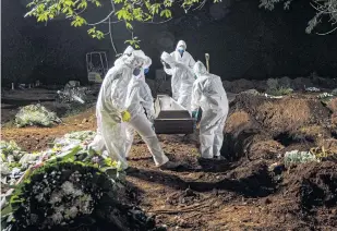  ??  ?? Workers in protective gear bury Covid-19 victims at the Vila Formosa Cemetery in Sao Paulo.