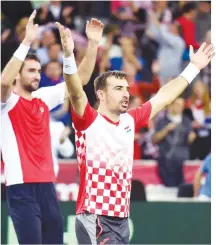  ??  ?? CROATIA’S TENNIS PLAYERS Ivan Dodig (C) and Marin Cilic (rear L) celebrate after winning the Davis Cup World Group final doubles match between Croatia and Argentina at the Arena hall in Zagreb, on Nov. 26.