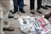  ??  ?? Zimbabwean­s check newspapers in Harare yesterday. The day followed a night of unrest that included a military takeover of the state broadcaste­r. Picture: AP