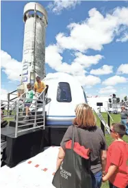  ??  ?? Daniel Farias and son Diego of Avon, Ind., exit the crew capsule of the Blue Origin rocket Monday.