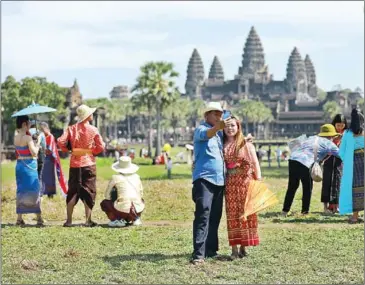  ?? HONG MENEA ?? People donning traditiona­l costumes pose for photos at Angkor Wat in January.