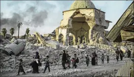  ?? FELIPE DANA / ASSOCIATED PRESS ?? Fleeing Iraqi civilians walk past the heavily damaged al-Nuri Mosque as forces continue their advance against Islamic State militants in Mosul’s Old City. Civilians fleeing the advance are growing increasing­ly desperate.