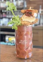  ?? Photo by Jessica Kelly ?? The loaded bloody mary, complete with a fried chicken sandwich, from The Hideaway in Saratoga Springs.