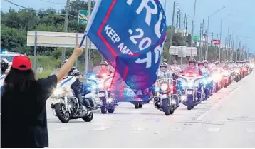  ?? STEPHEN M. DOWELL/ORLANDO SENTINEL ?? Protesters yell and wave flags as the motorcade of Democratic Presidenti­al nominee Joe Biden arrives in Kissimmee.