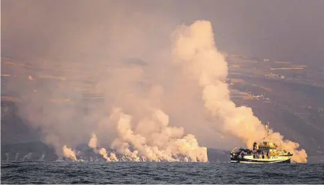  ?? FOTO: DANIEL ROCA/DPA ?? Ein Schiff ist nahe La Palma im Einsatz, während auch Tage nach Ausbruch des Vulkans Lava ins Meer fließt.