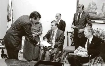  ?? Courtesy Lex Frieden ?? Vice President George H.W. Bush receives the Americans with Disabiliti­es Act proposal in 1986 from policy expert Lex Frieden, along with Jeremiah Milbank, from left, Boyden Gray and Justin Dart Jr.