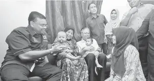  ?? — Gambar Bernama ?? MESRA: Lokman (duduk kiri) beramah mesra bersama penduduk ketika Program Ziarah Kasih di Kampung Jawa di Klang semalam.