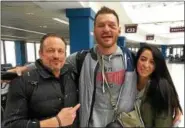  ?? MARK PODOLSKI - THE NEWS-HERALD ?? UFC heavyweigh­t champion Stipe Miocic,with head coach Marcus Marinelli and wife Ryan, after arriving at Cleveland Hopkins Internatio­nal Airport from Boston on Jan. 21.
