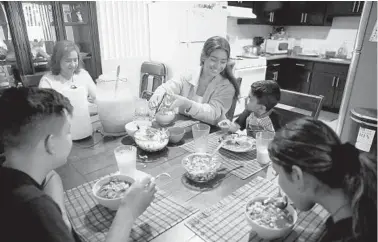  ?? GARY CORONADO/LOS ANGELES TIMES ?? Stephanie Contreras-Reyes, 17, center, eats homemade pozole with brother Ismael Contreras-Reyes, 13, from left, mother Teresa Reyes, brother Cristian Contreras-Reyes, 5, and sister Ashley Contreras-Reyes, 16, on Dec. 11 in Los Angeles. Stephanie is at the top of her class at Orthopaedi­c Hospital Medical Magnet High School.
