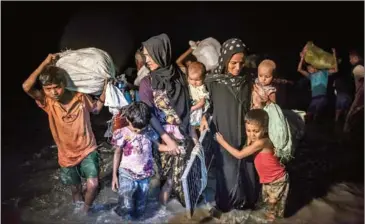  ?? SERGEY PONOMAREV/THE NEW YORK TIMES ?? After crossing the Naf River by boat, Rohingya refugees from Myanmar arrive near the the village of Shah Porir Dwip, in Bangladesh, on September 27.