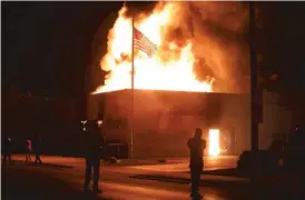  ??  ?? A building burns Monday night in Kenosha, Wisconsin.