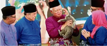  ??  ?? Cute gift: Najib is given a cat by Puteri Umno leader Datuk Mas Ermieyati Samsudin (right) at Masjid Tanah in Melaka. Looking on are (from left) Melaka Chief Minister Datuk Seri Idris Haron, Dr Ahmad Zahid and Abd Rauf.