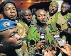  ?? Picture: AFP ?? ARMED RESPONSE: Spokesman of mutinous soldiers Issiaka Ouattara, centre, speaks to journalist­s after negotiatio­ns with Ivory Coast defence minister Alain Richard Donwahi on Saturday in Bouake. Donwahi had been detained by rebels-turned-soldiers