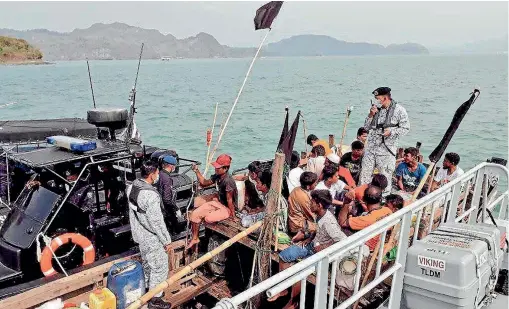  ??  ?? Malaysian navy officers detaining a boat carrying a group of Rohingya Muslim migrants seeking refuge off Langkawi, Malaysia, this month. The Rohingya are denied citizenshi­p in their home country of Myanmar.