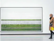  ?? FOTO: DPA ?? Eine Besucherin betrachtet in der Hayward-Gallery in London das Werk „Rhein III“des deutschen Fotokünstl­ers Andreas Gursky.