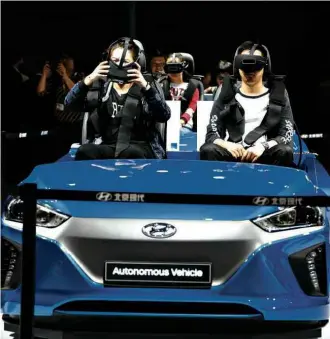  ?? Ng Han Guan/Associated Press ?? » IRREAL Visitantes do Salão de Xangai testam veículo autônomo com equipament­o de realidade virtual; evento é um dos mais importante­s do mundo na indústria automotiva CRÉDITO