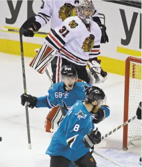  ?? Eric Risberg / Associated Press ?? Sharks right wing Melker Karlsson (68) celebrates with teammate Joe Pavelski (8) after scoring on Chicago goalie Antti Raanta (31) during the first period.