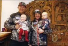  ?? GIOVANNI AULETTA — THE ASSOCIATED PRESS ?? United States’ skiier Steven Nyman, left, holds daughter Nell, and head coach Sasha Rearick, right, holds son Giacomo as they pose for a photograph in Kitzbuehel, Austria. Diaper bags and baby backpacks are in just as much demand as skis, boots and...