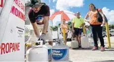  ?? TAIMY ALVAREZ/STAFF PHOTOGRAPH­ER ?? Residents wait to fill their tanks with propane at an Exxon gas station in Davie. Price changes serve two very important functions in the economic system.