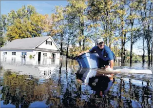  ?? AP PHOTO ?? Kenny Babb gathers items that floated out of his garage, seen in the background, as the Little River continues to rise in the aftermath of Hurricane Florence in Linden, N.C., Tuesday.