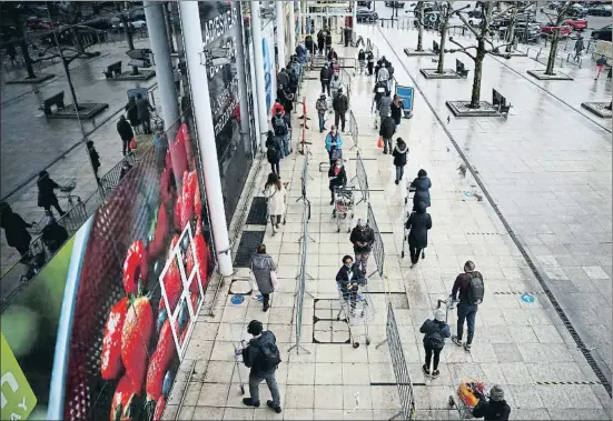  ?? HANNAH MCKAY / REUTERS ?? Londinense­s haciendo ayer cola frente a un supermerca­do