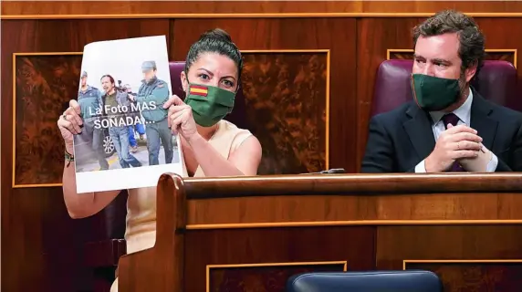  ?? EP ?? La diputada de Vox, Macarena Olona, ayer, con un fotomontaj­e de Iglesias detenido por la guardia civil con el título: «La foto más sonada»; augurandol­e que acabará así