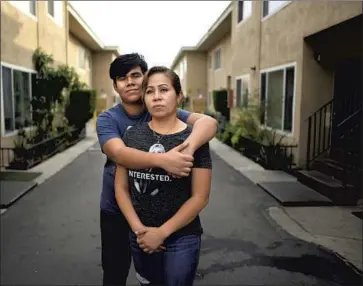  ?? Wally Skalij Los Angeles Times ?? EIGHTH- GRADER Adrian Rivera hugs his mother, Yesica Aguirre. Her husband is vulnerable to COVID- 19, and Adrian does well with online learning, but Aguirre said in- person classes would be best for Adrian.