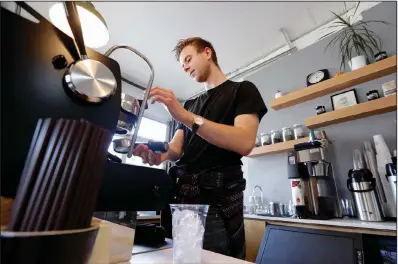  ?? (AP/Elaine Thompson) ?? A barista makes an iced coffee drink for a customer last fall in a Seattle coffee shop. The U.S. services sector had a surge of growth in February.