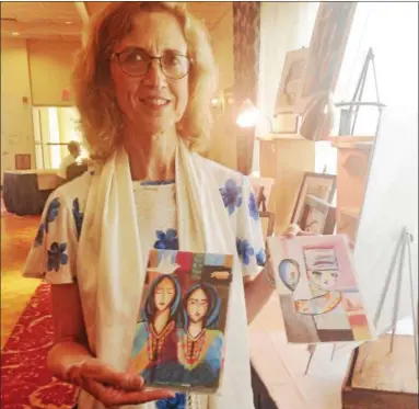  ?? BOB KEELER — DIGITAL FIRST MEDIA ?? Dr. Patricia Reiff, owner and director of Associates in Hearing, Lansdale, stands with cards in the Syrian Refugee Art Show.