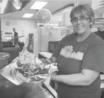  ?? ANDREW VAUGHAN/THE CANADIAN PRESS ?? Donna Lawlor prepares a donair at King of Donair in Dartmouth. Halifax regional council voted 12-4 in favour of a staff report that will consider approving the unique treat as the city’s official food.