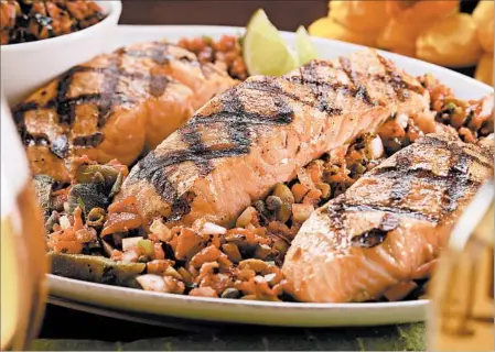  ?? MICHAEL TERCHA/CHICAGO TRIBUNE PHOTOS; MARK GRAHAM/FOOD STYLING ?? Grilled salmon with poblanos and salsa Veracruzan­a, a blend of tomatoes, olives, capers and jalapenos.